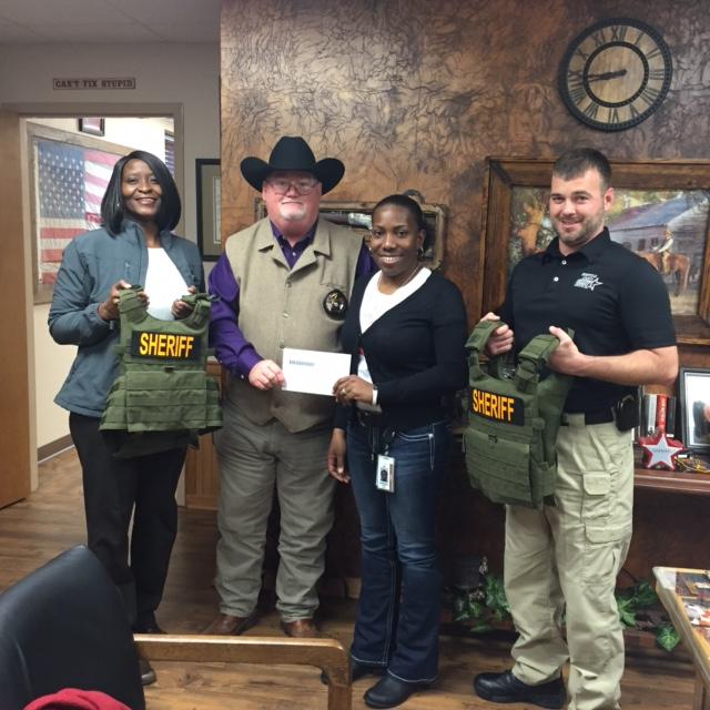 Pam Gibbs, Sheriff Singleton, Andrea Hale, and Justin Crane standing with vests