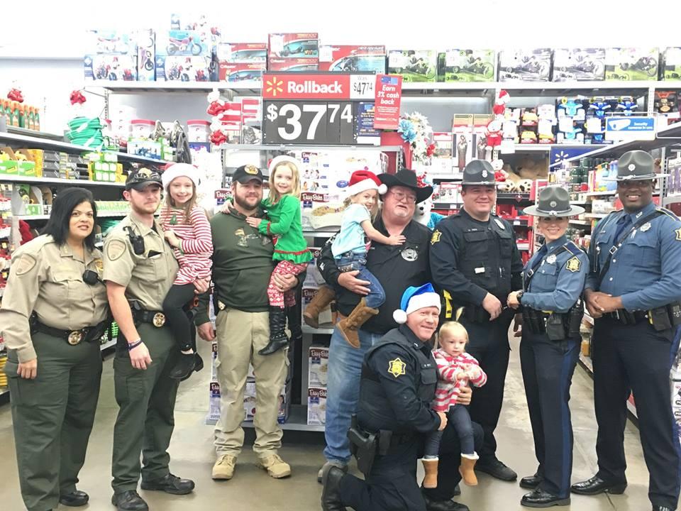 Sheriff's Office staff and young children standing in walmart aisle smiling