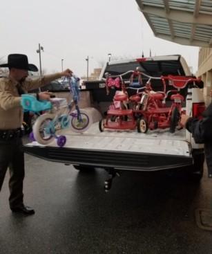 Deputy loading children's bikes into bed of truck